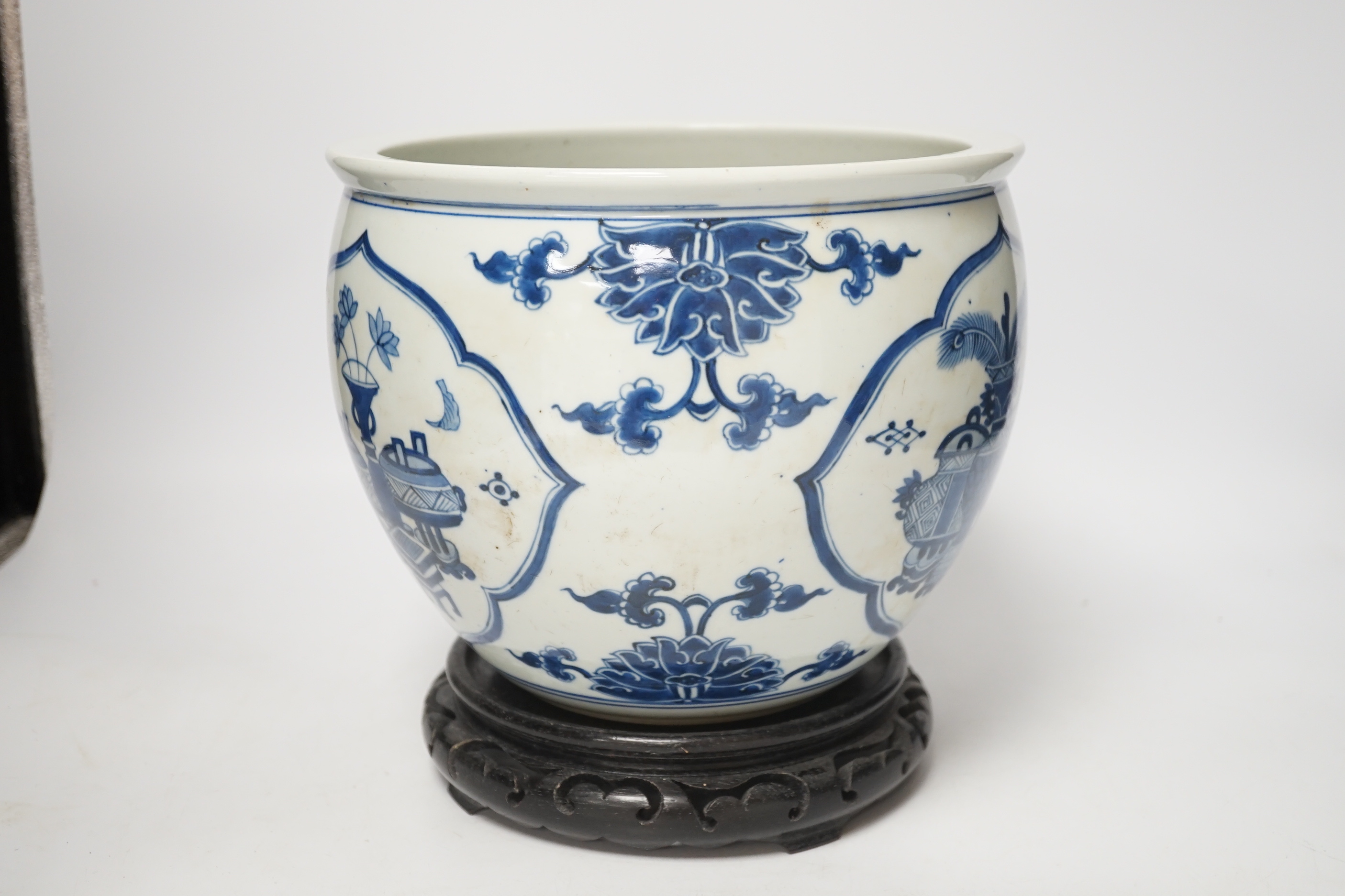 A Chinese blue and white jardiniere and hardwood stand, total height 23cm